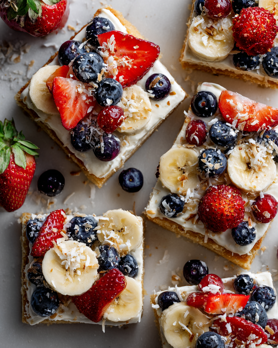Colorida pizza de frutas con base de galleta, ideal para celebraciones, postre festivo fácil y delicioso.