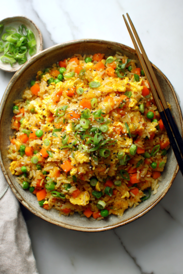 Explosión de Sabor: Arroz Frito para Compartir Delicioso arroz frito colorido y sabroso, ideal para reuniones familiares y festividades con amigos.